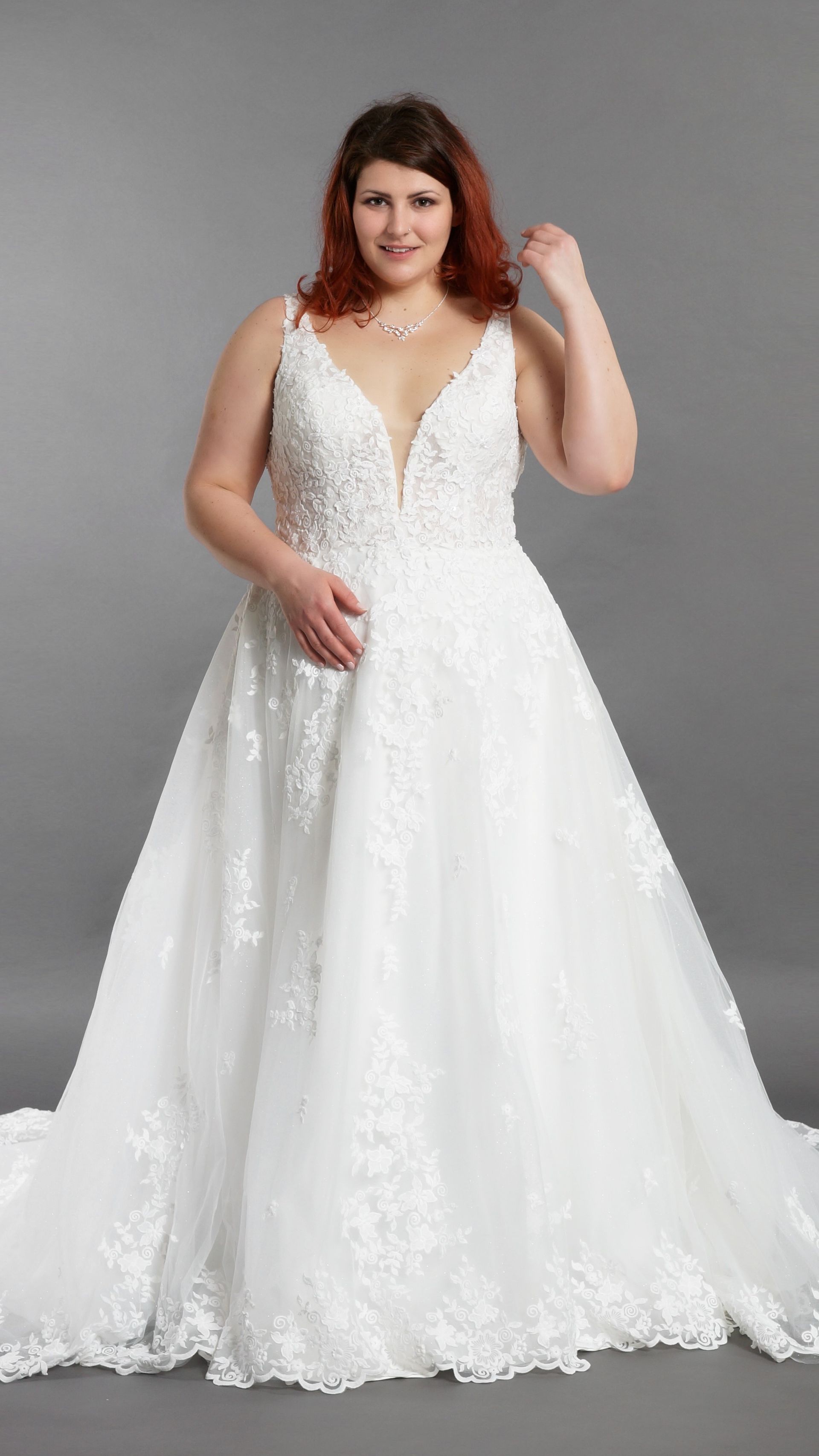 Eine Frau mit Übergröße trägt ein weißes Brautkleid.