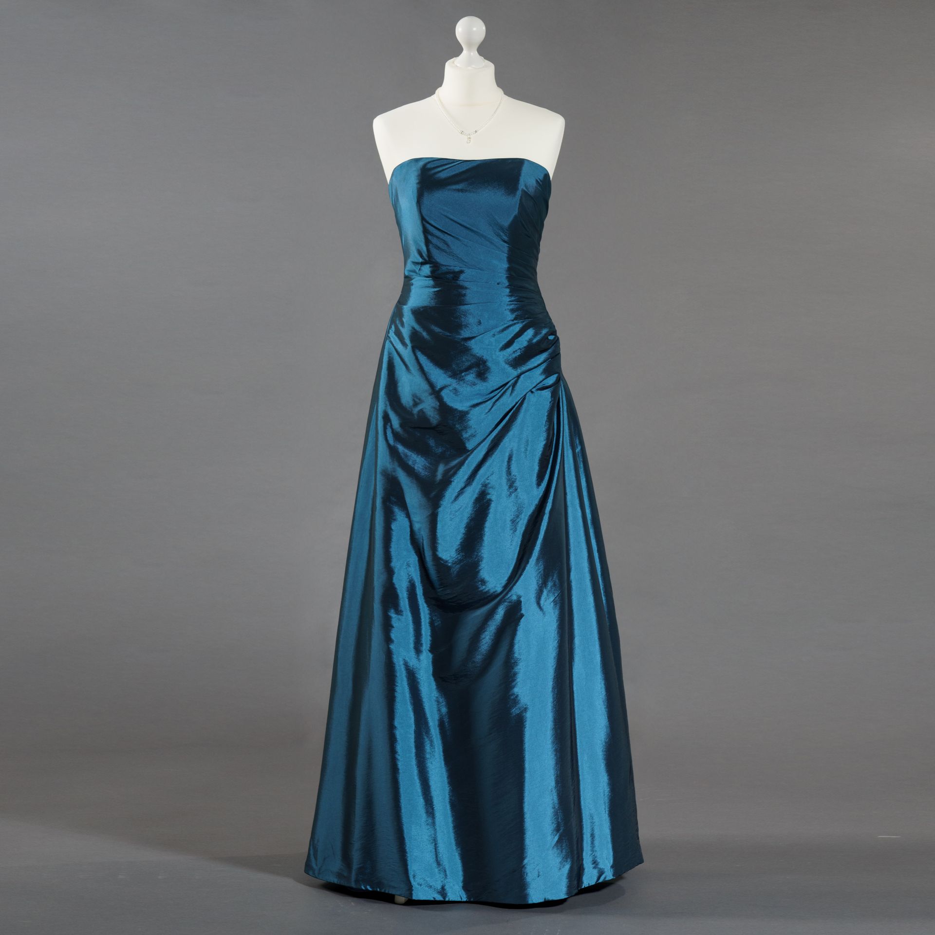 Ein blaues trägerloses Kleid hängt an einer Schaufensterpuppe