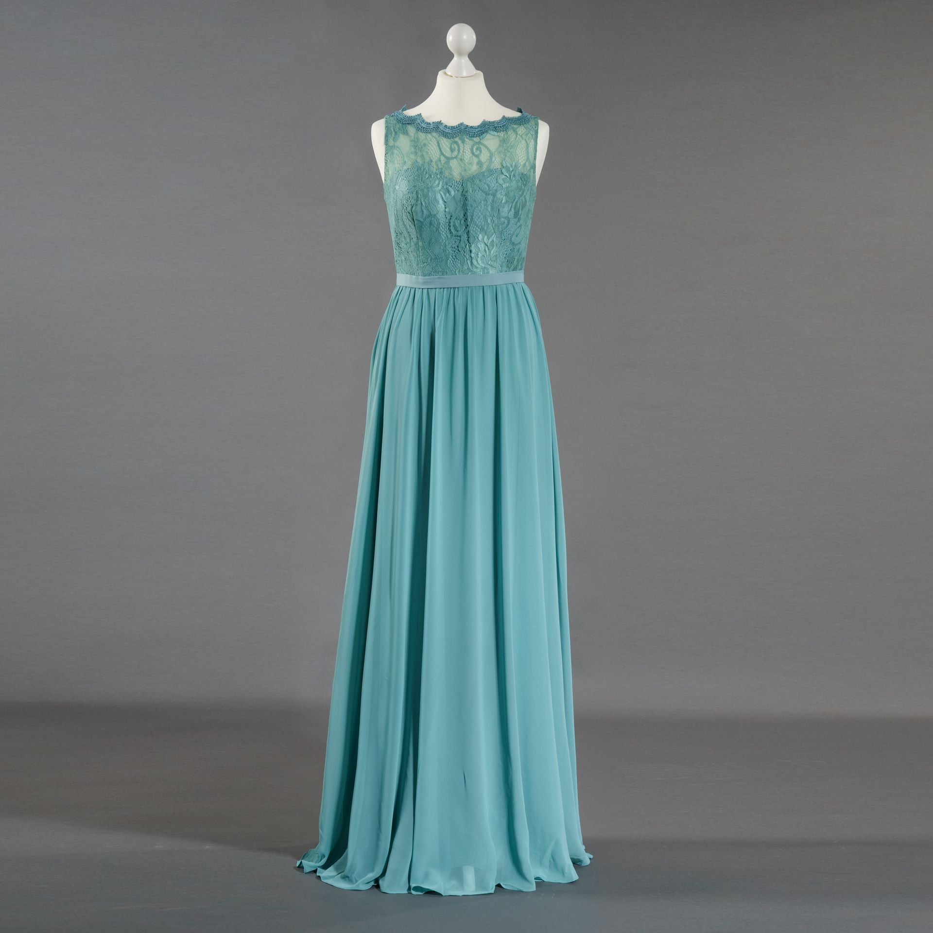 Ein blaues Kleid hängt auf einer Schaufensterpuppe mit grauem Hintergrund