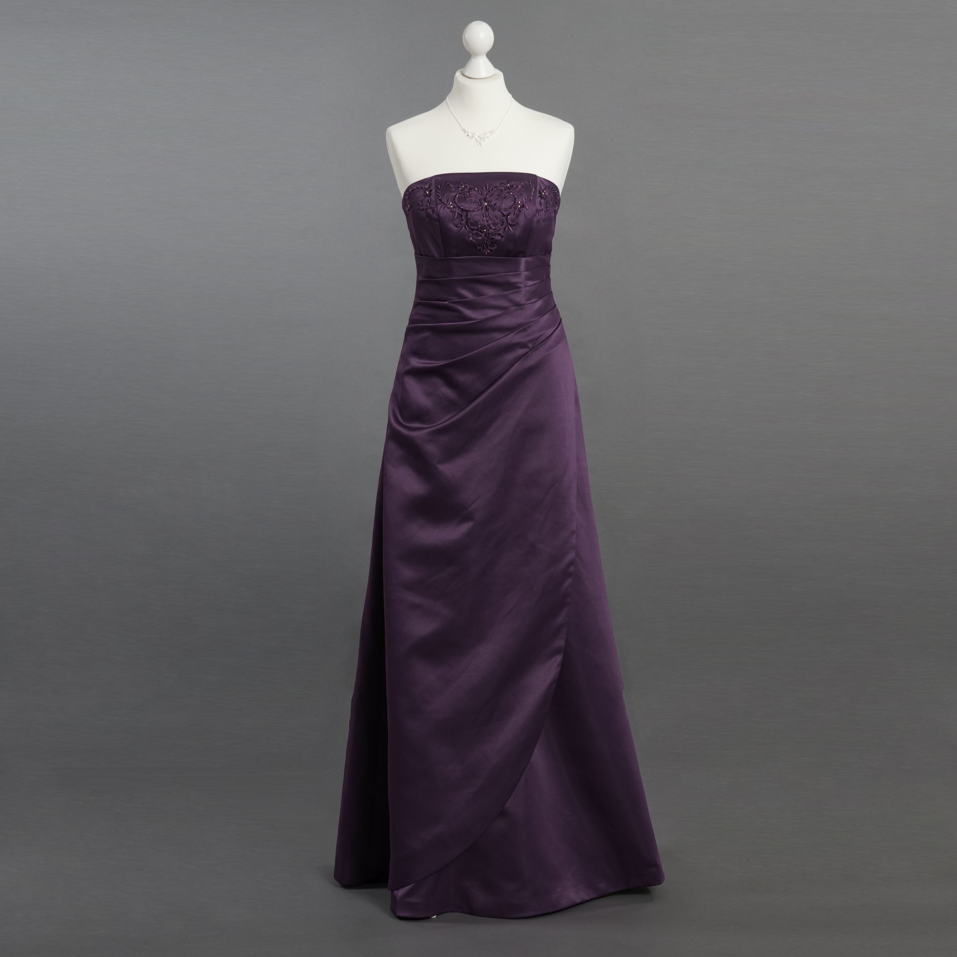 Ein lila trägerloses Kleid ist auf einer Schaufensterpuppe