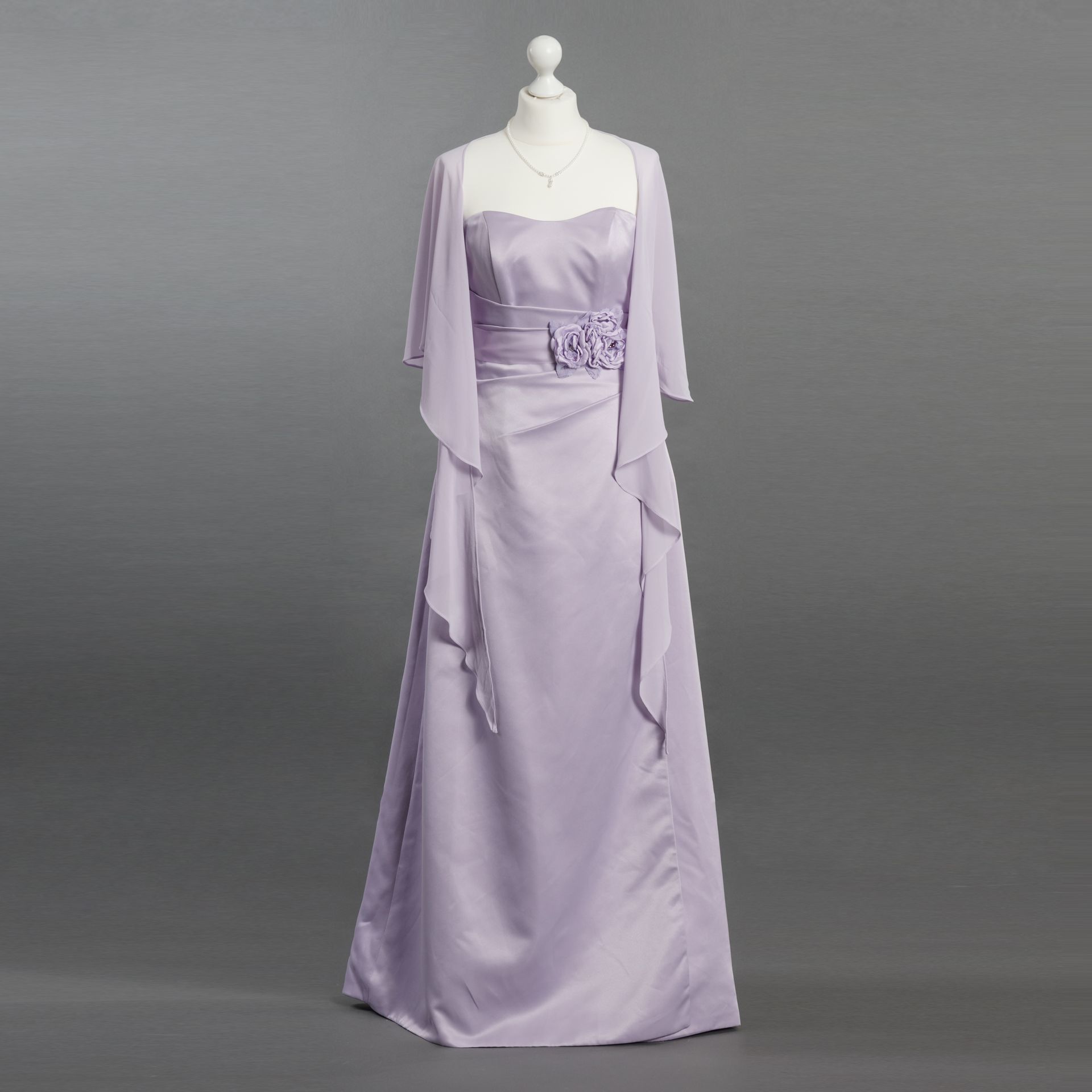 Eine Schaufensterpuppe trägt ein langes lila Kleid