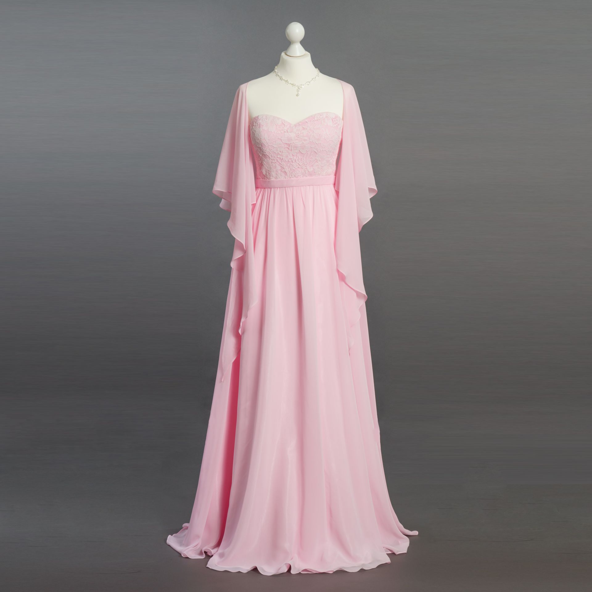 Ein rosa Kleid mit langen Ärmeln ist auf einer Schaufensterpuppe