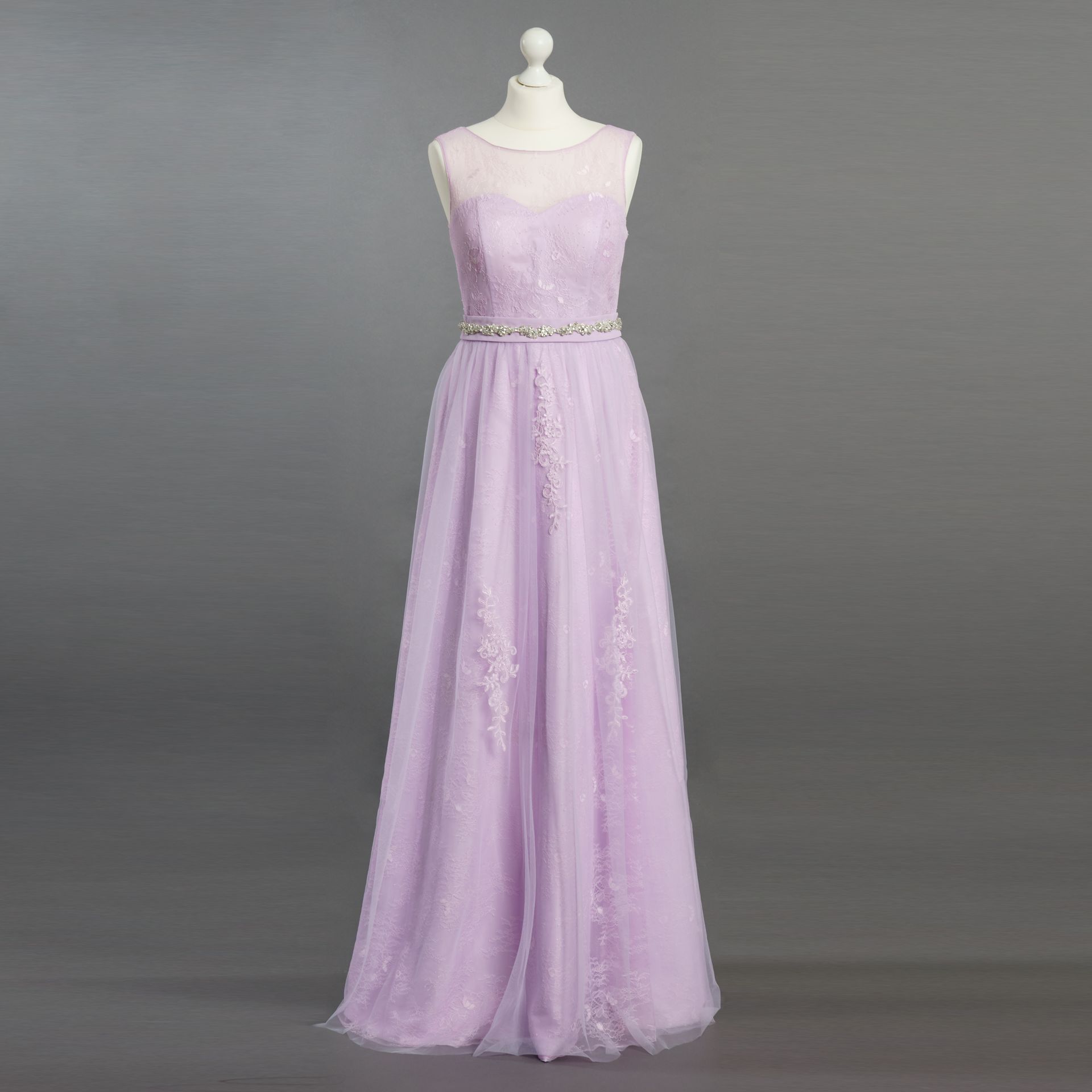 Auf einer Schaufensterpuppe hängt ein lila Brautjungfernkleid.