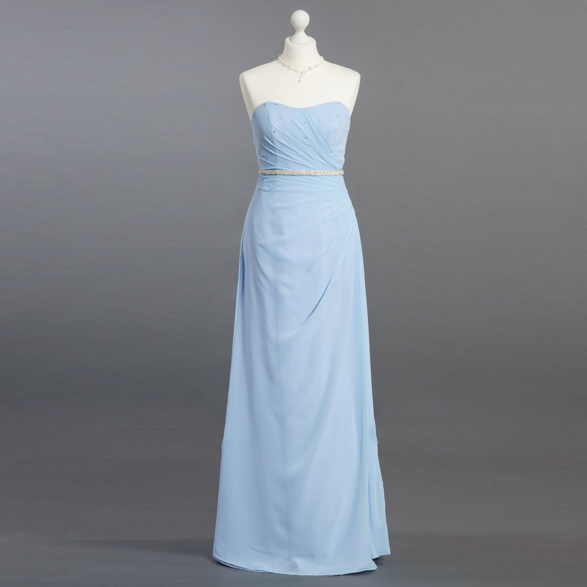 Ein hellblaues trägerloses Kleid hängt an einer Schaufensterpuppe