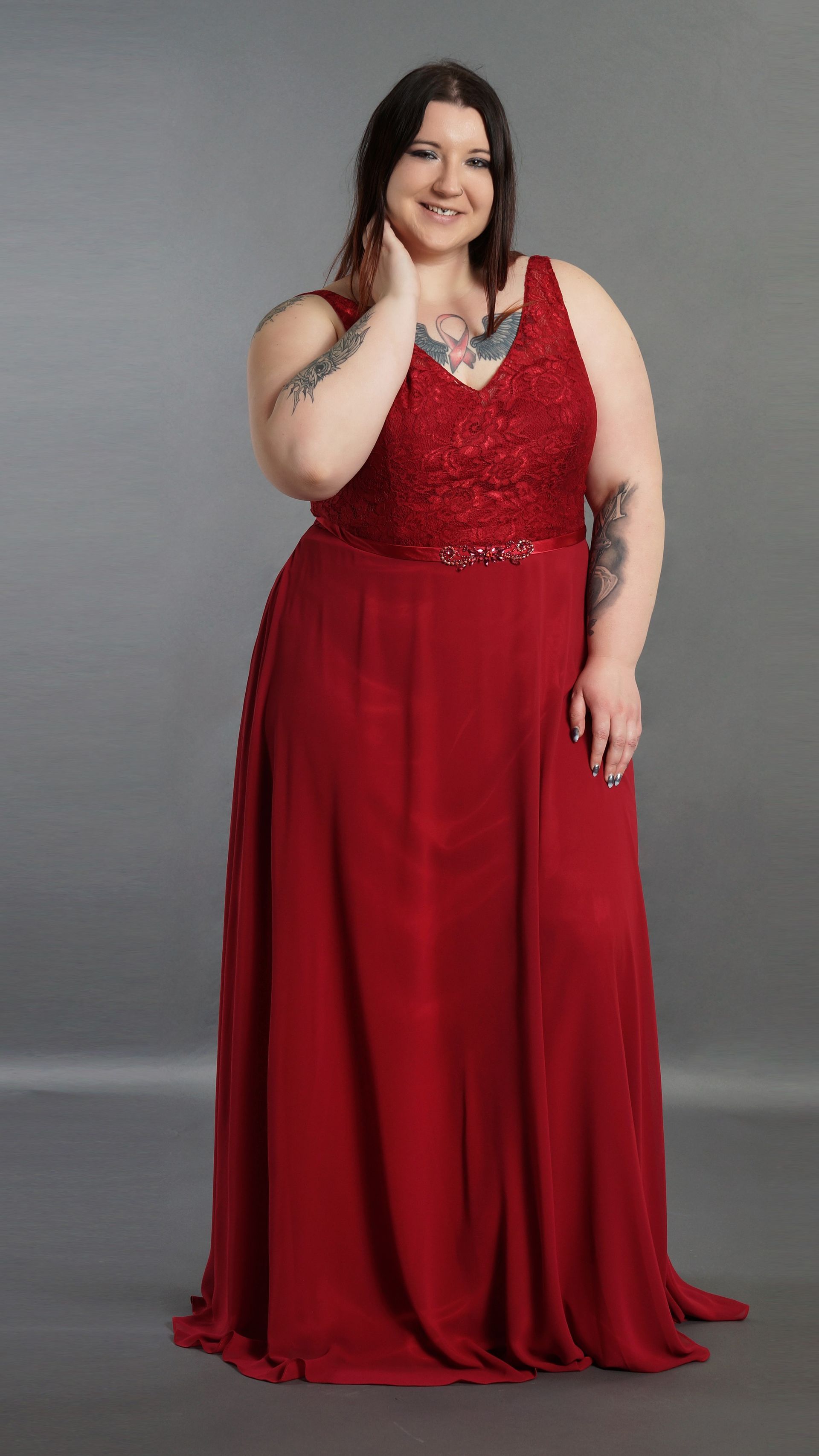 Eine Frau mit Übergröße trägt ein langes rotes Kleid.