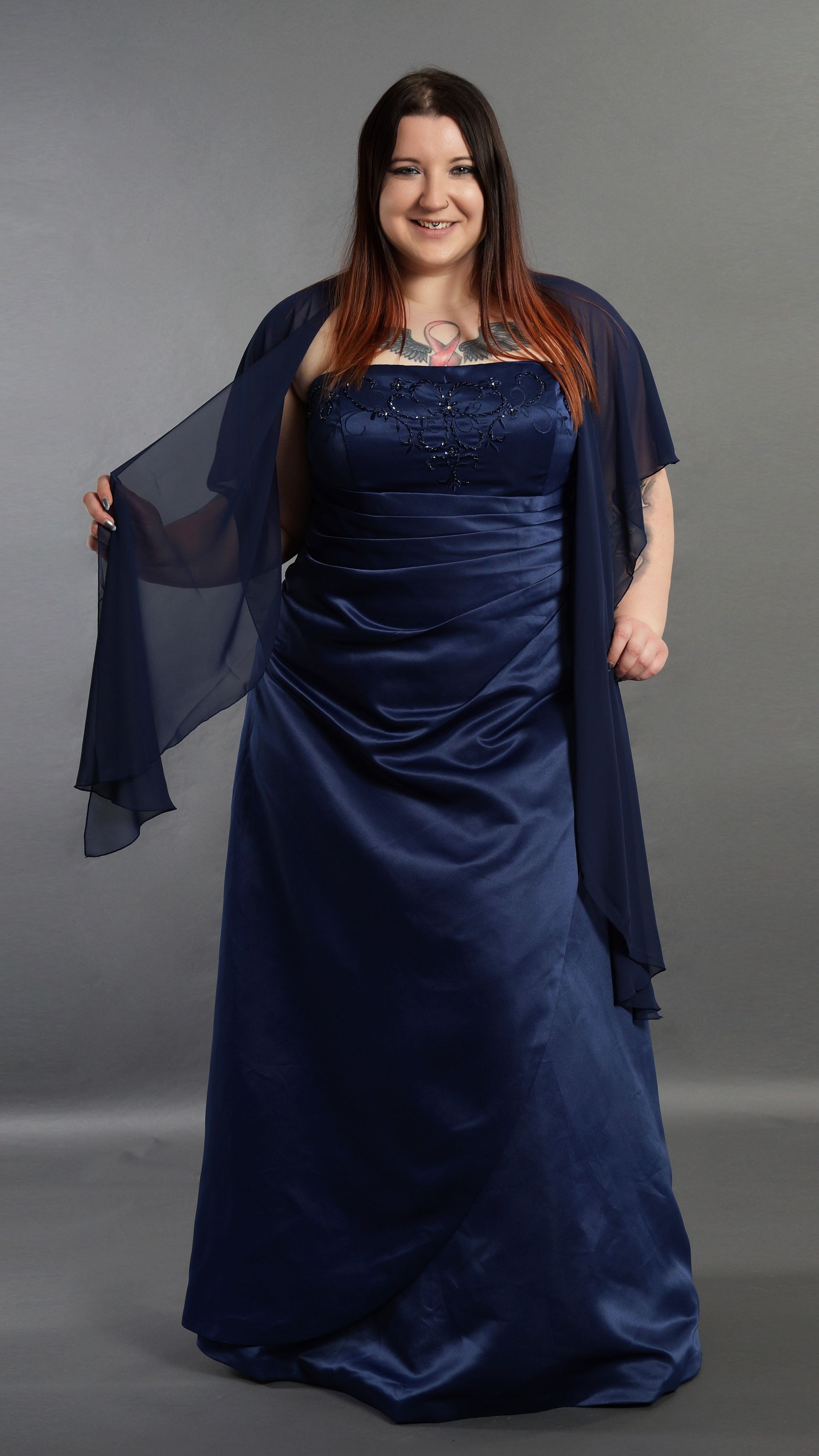 Eine Frau trägt ein blaues Kleid und einen Schal.