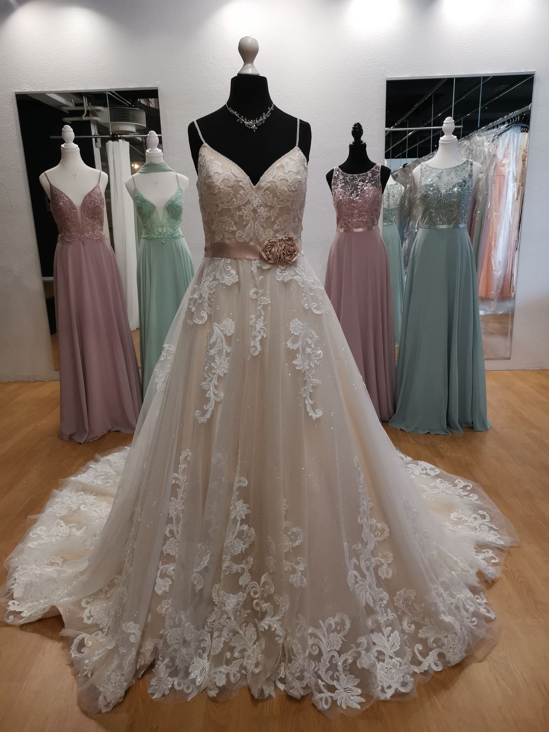 In einem Geschäft hängt an einer Schaufensterpuppe ein Brautkleid.