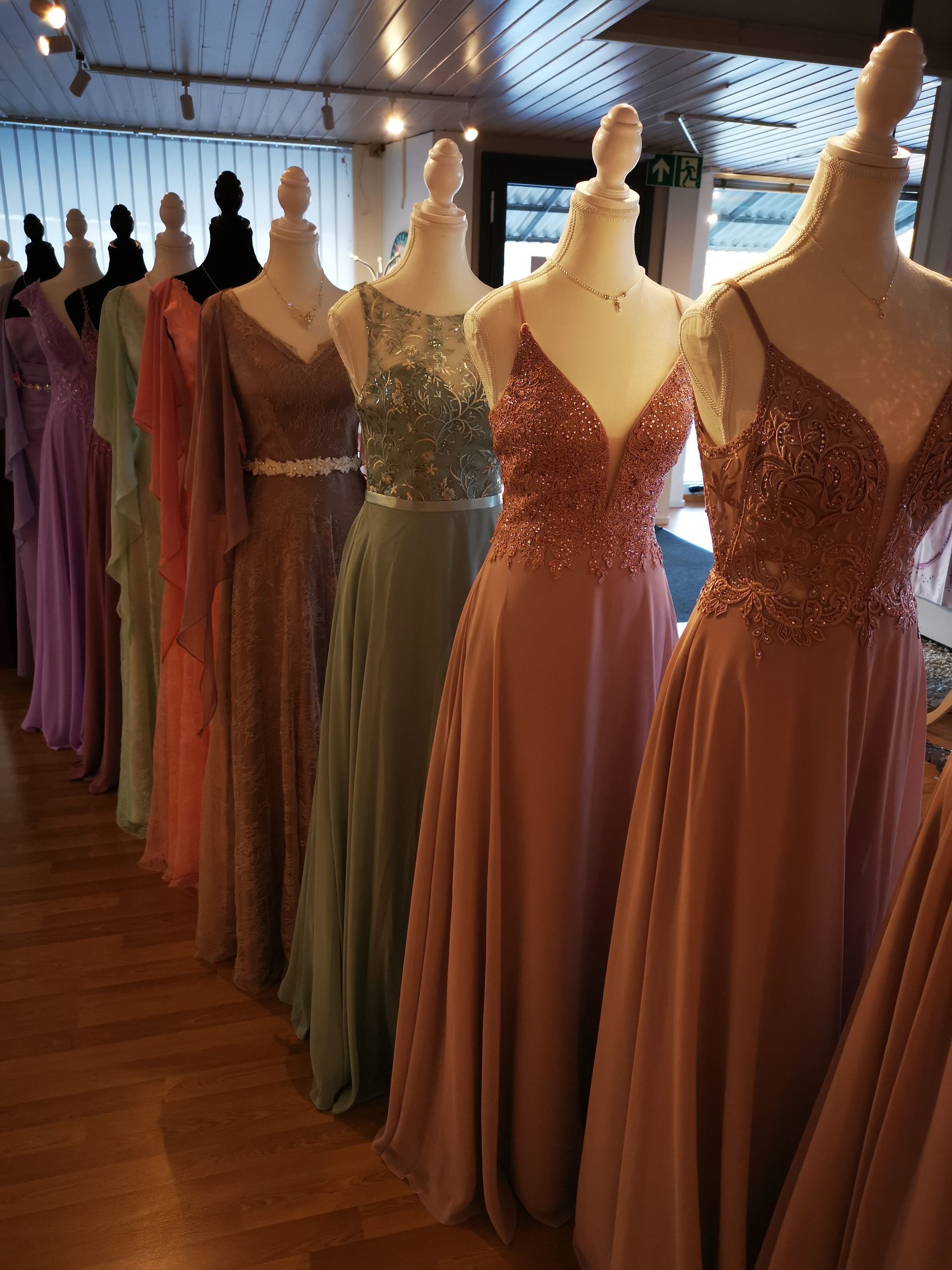 Eine Reihe von Kleidern auf Schaufensterpuppen in einem Geschäft.