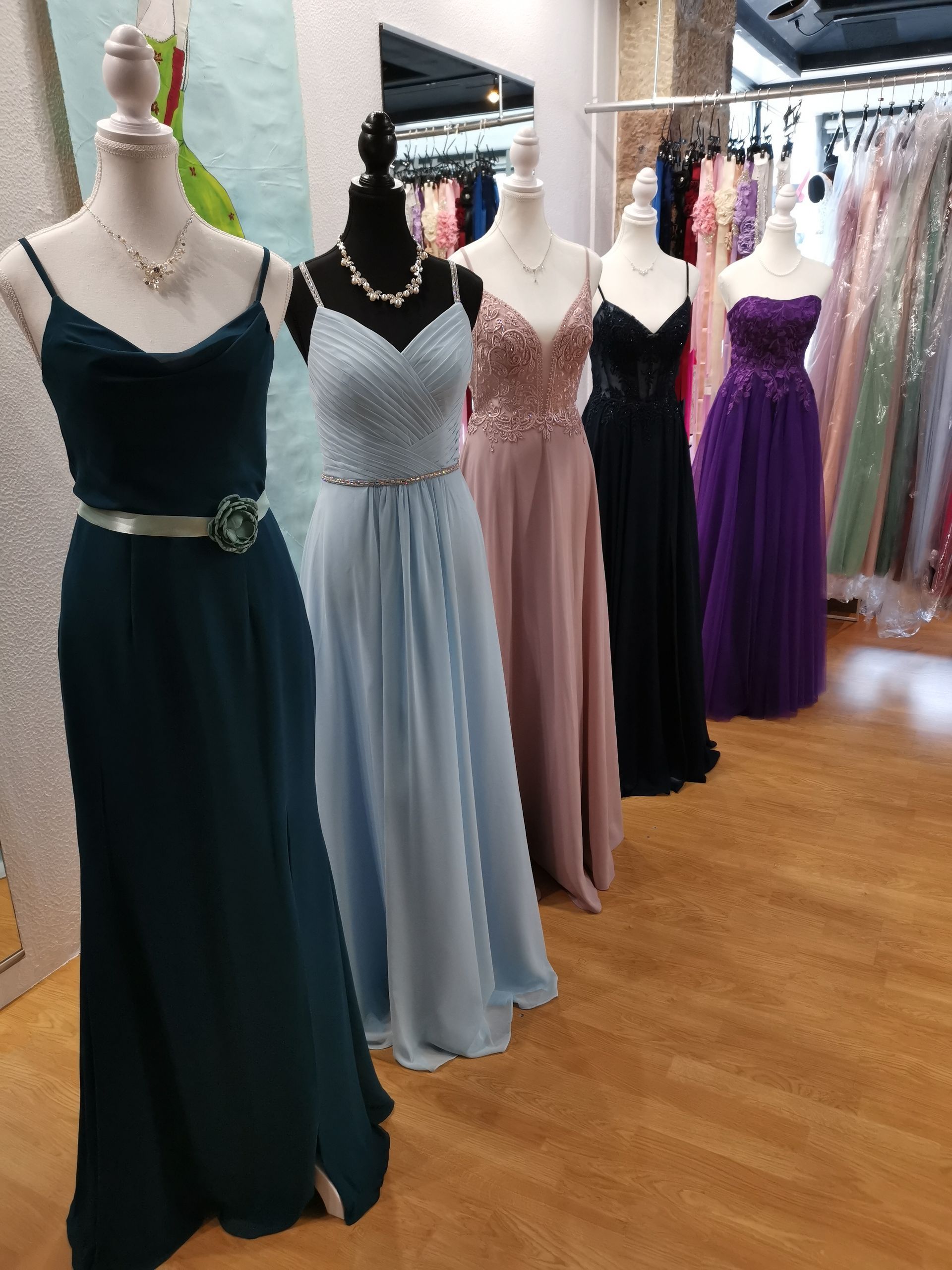 Eine Reihe von Kleidern auf Schaufensterpuppen in einem Geschäft