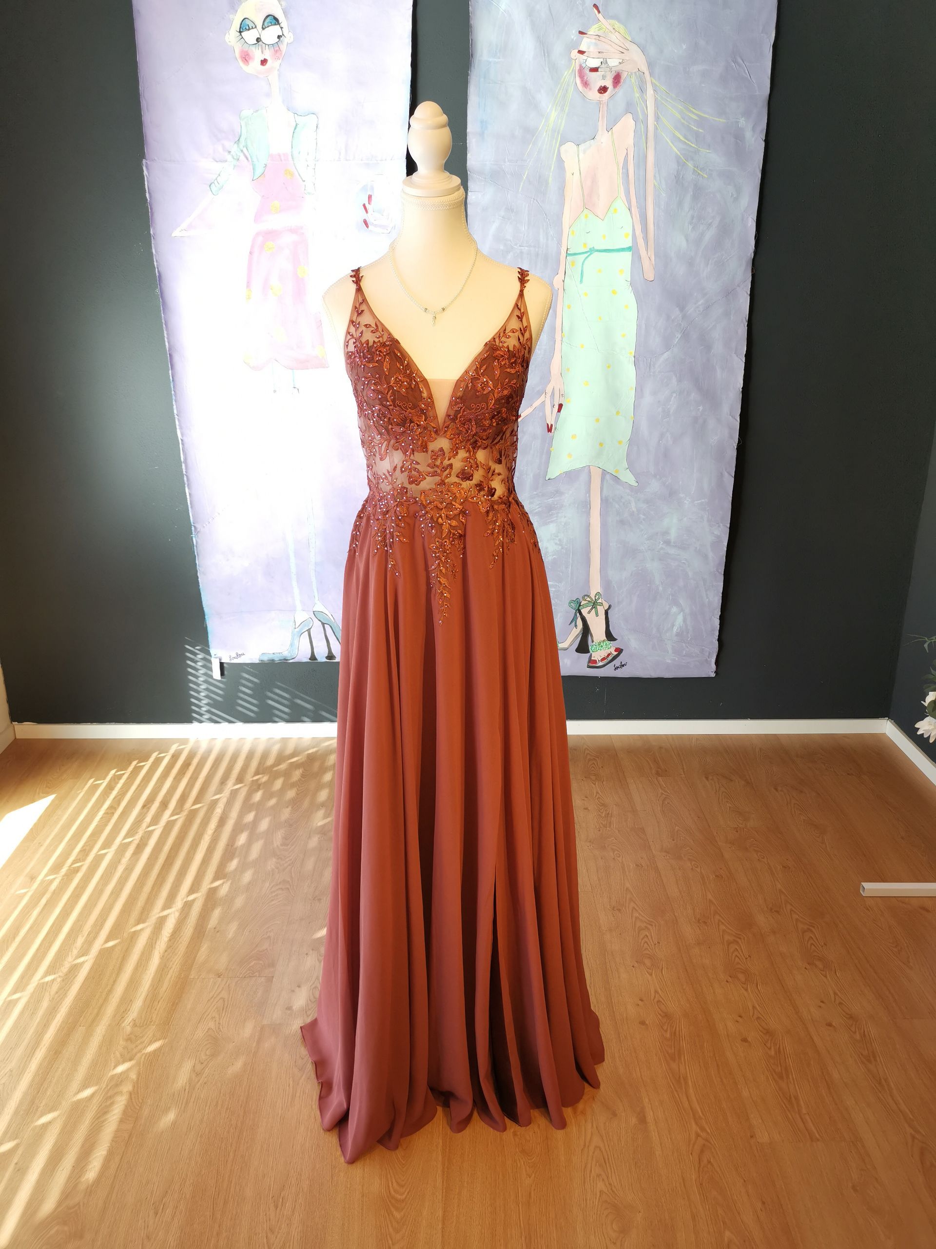 Ein rotes Kleid hängt an einer Schaufensterpuppe in einem Raum