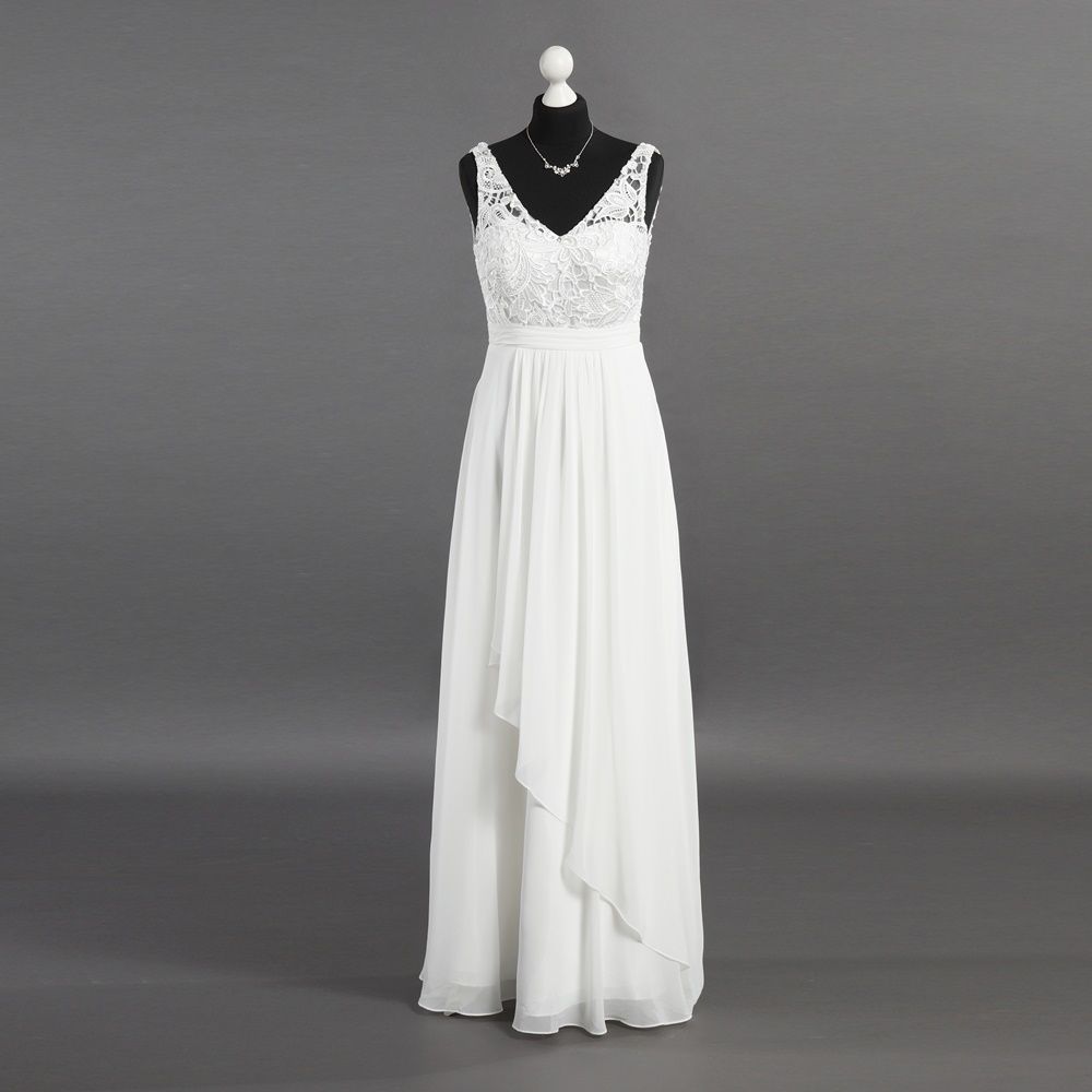 Ein weißes Kleid hängt auf einer Schaufensterpuppe mit grauem Hintergrund