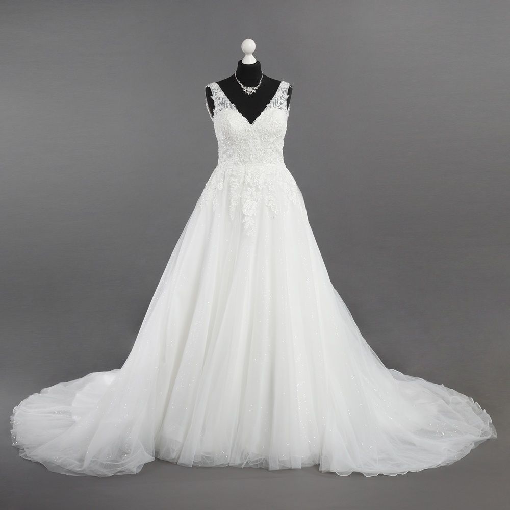 Ein weißes Brautkleid hängt an einer Schaufensterpuppe mit einer Halskette