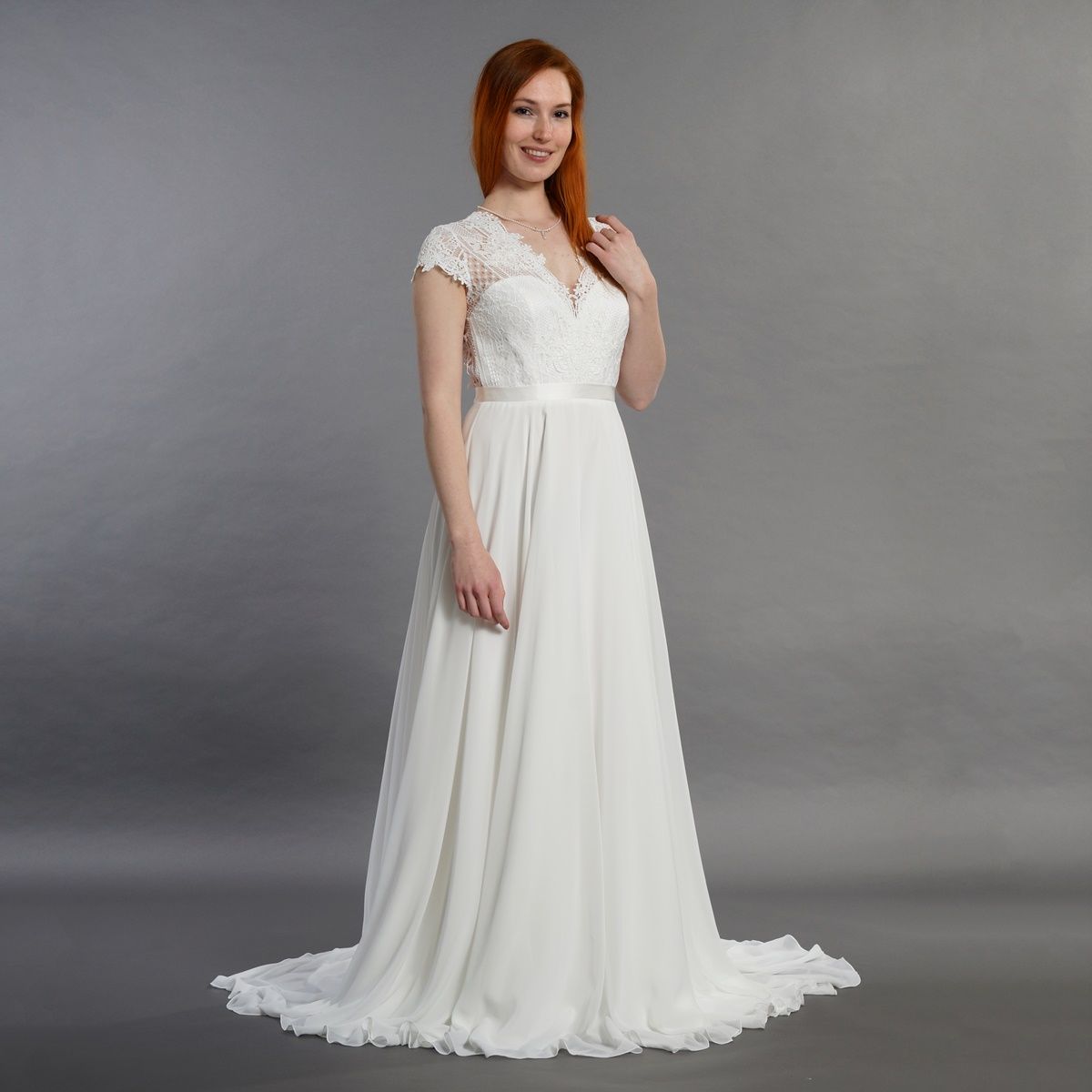 Eine Frau trägt ein weißes Brautkleid mit kurzen Ärmeln