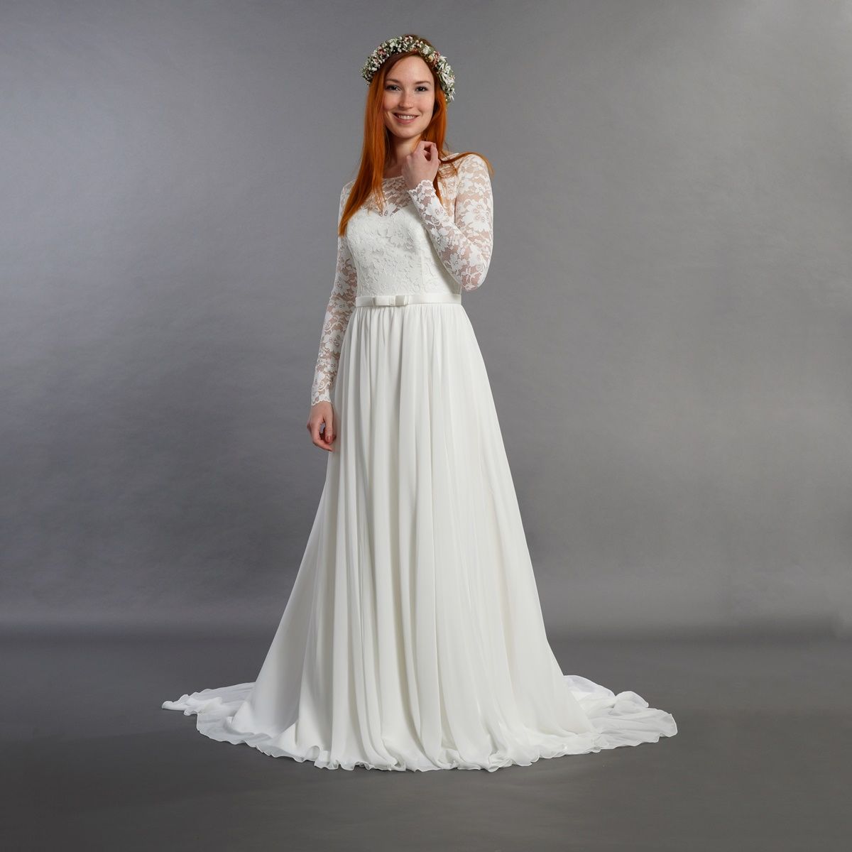 Eine Frau in einem weißen Brautkleid mit einem Blumenkranz auf dem Kopf.