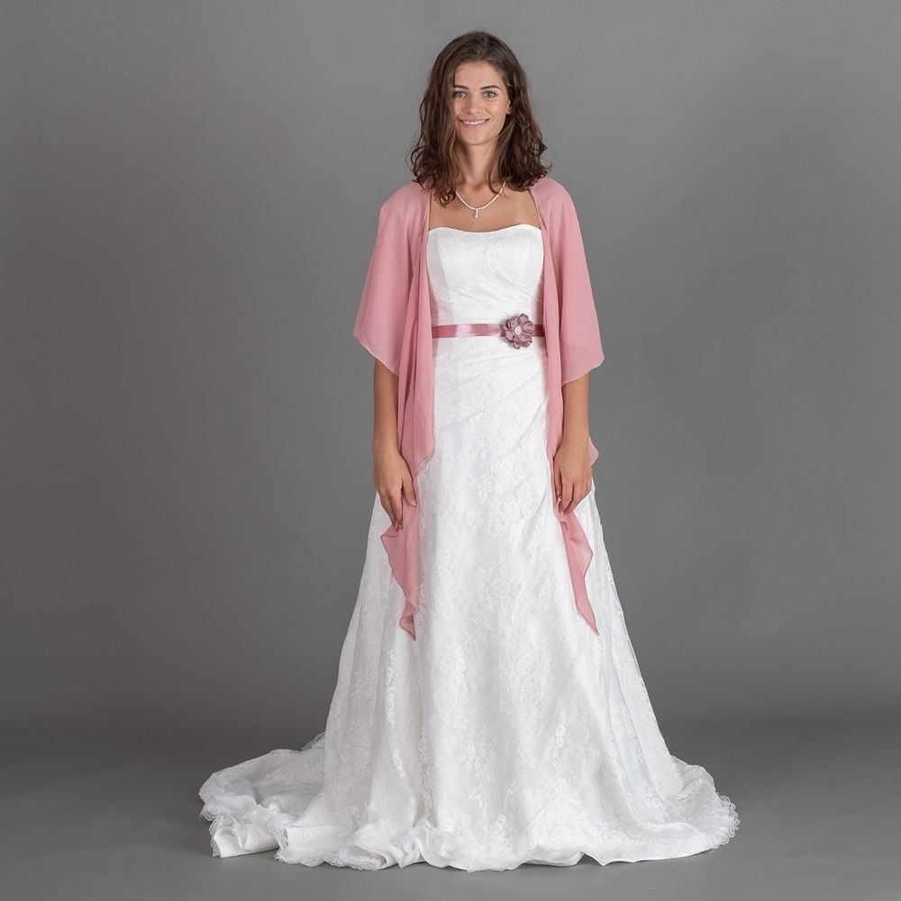 Eine Frau trägt ein weißes Brautkleid und eine rosa Jacke