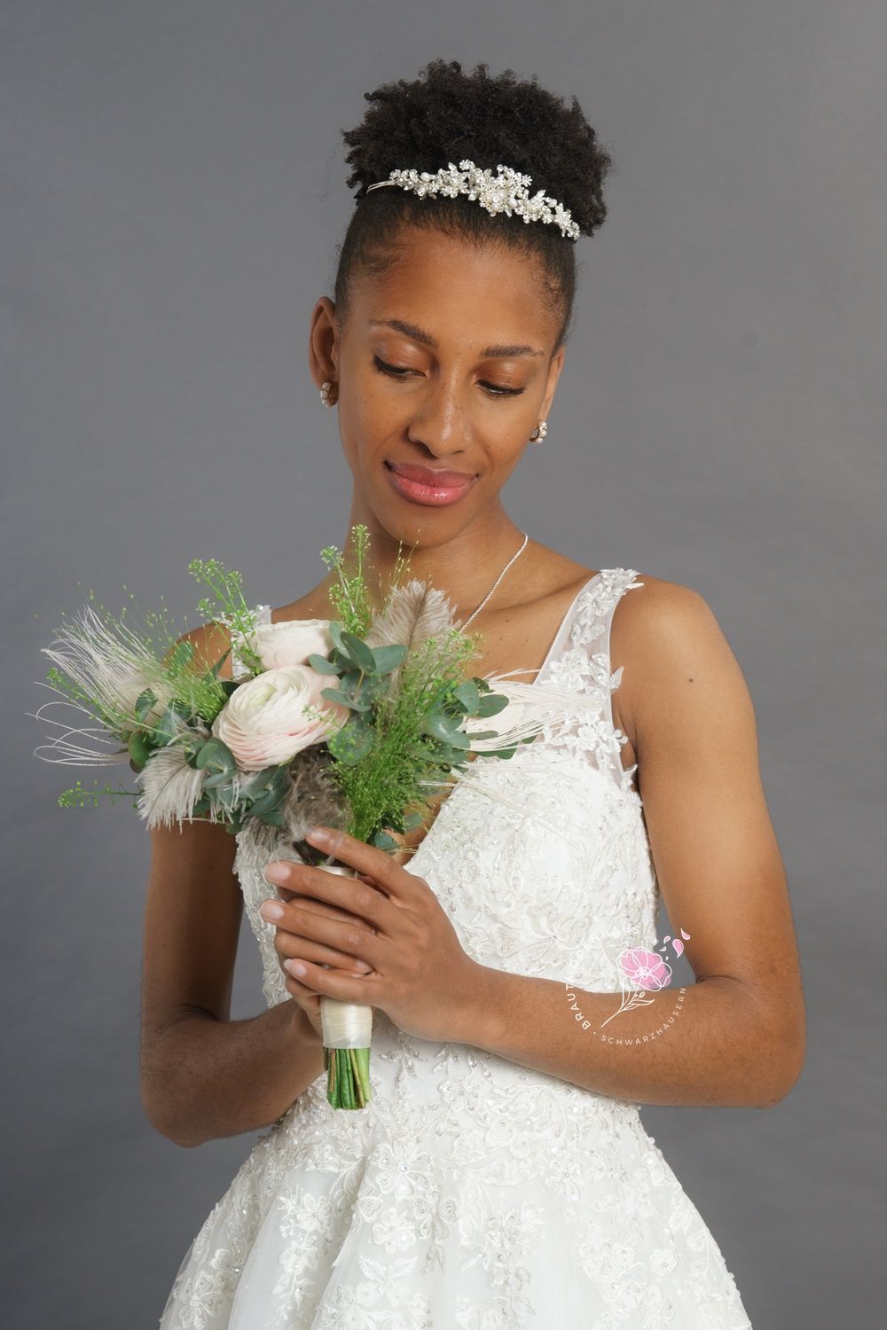 Eine Frau in einem Brautkleid hält einen Blumenstrauß.