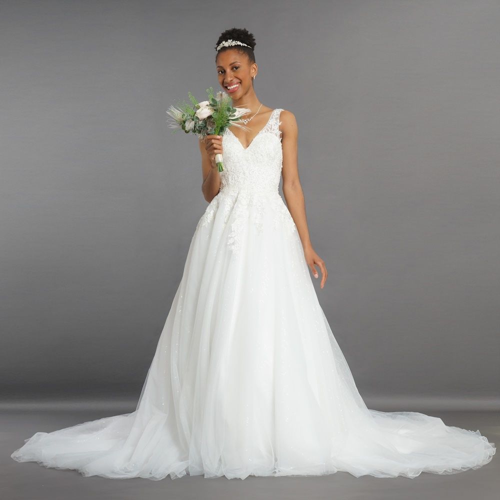 Eine Frau in einem weißen Brautkleid hält einen Blumenstrauß