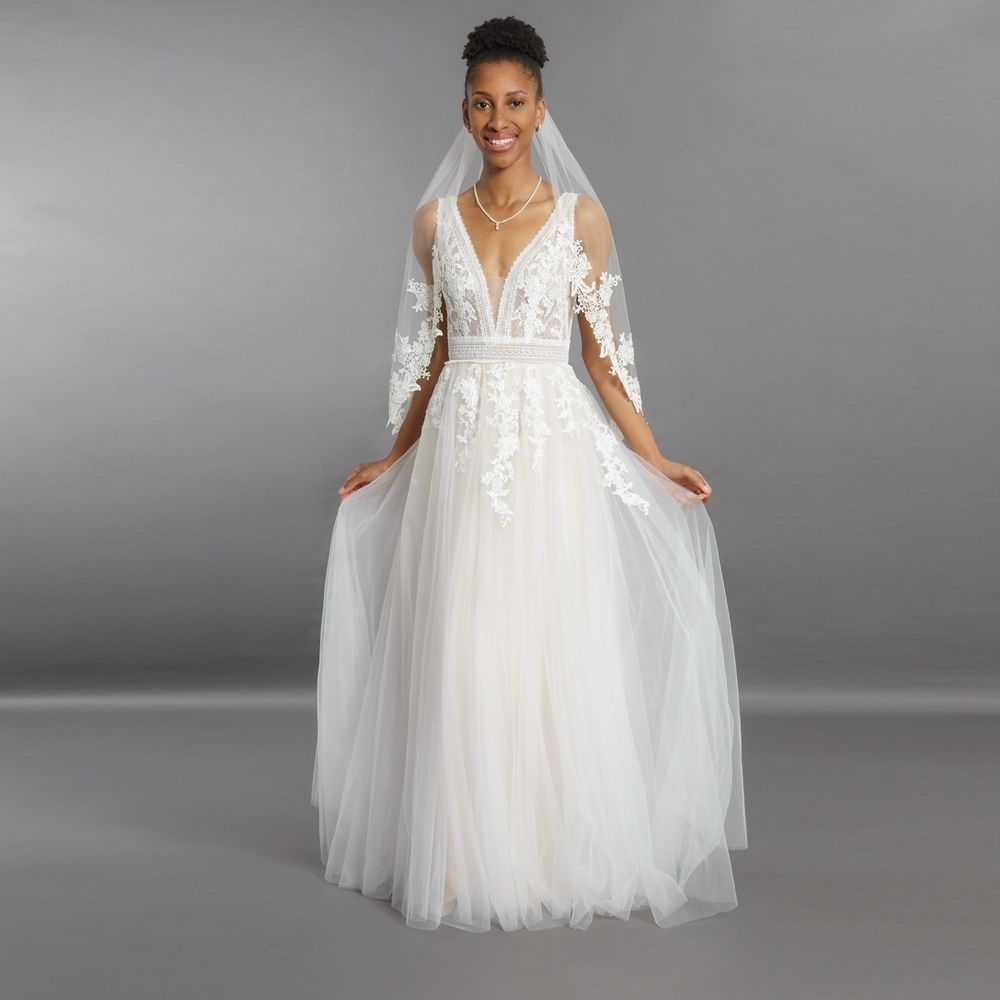 Eine Frau trägt ein weißes Brautkleid und einen Schleier.