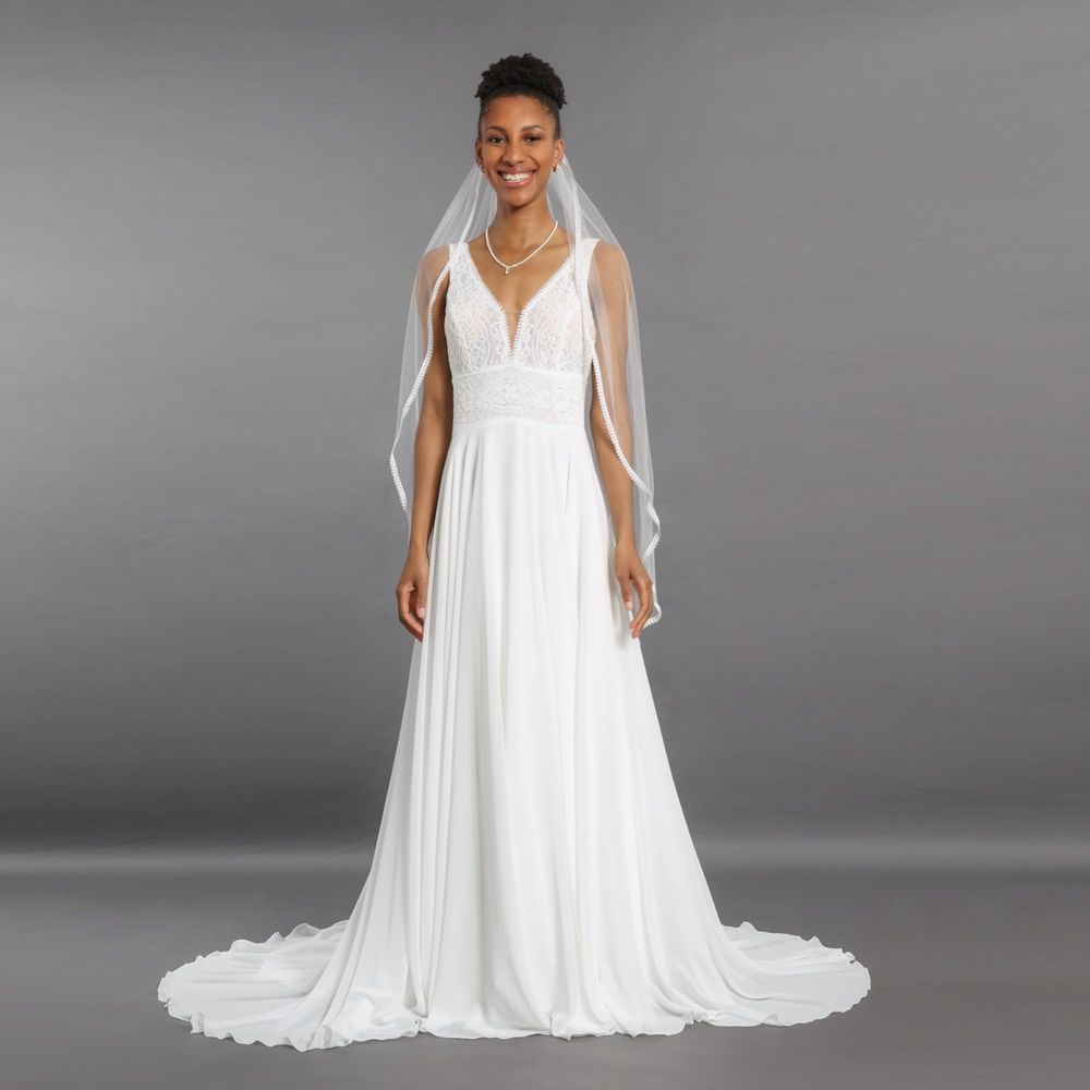 Eine Frau trägt ein weißes Brautkleid und einen Schleier