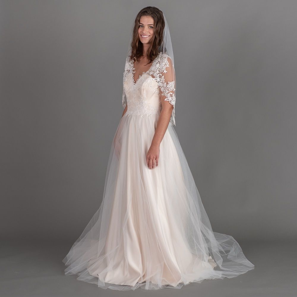 Eine Frau trägt ein Brautkleid und einen Schleier.