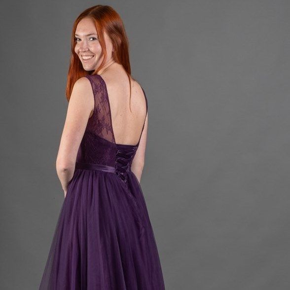 Der Rücken einer Frau, die ein lila Kleid trägt