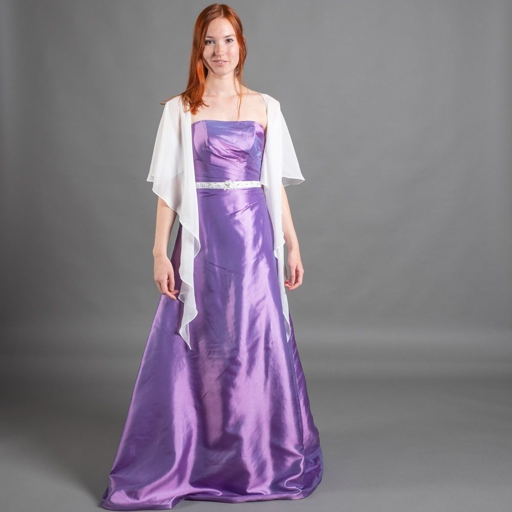 Eine Frau trägt ein lila Kleid und eine weiße Jacke