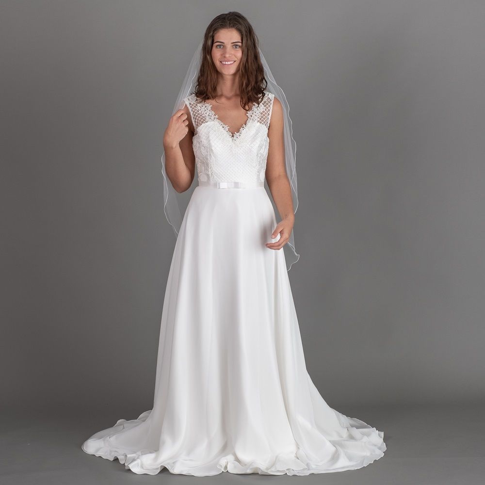 Eine Frau trägt ein weißes Brautkleid und einen Schleier.