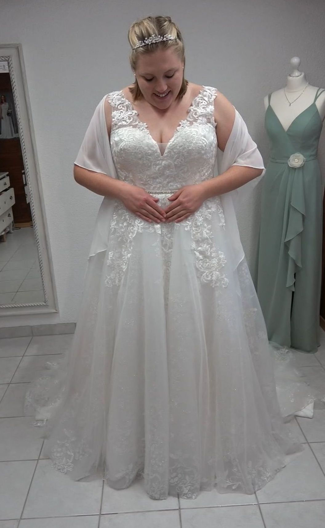 Eine Frau in einem Brautkleid steht vor einem Spiegel.