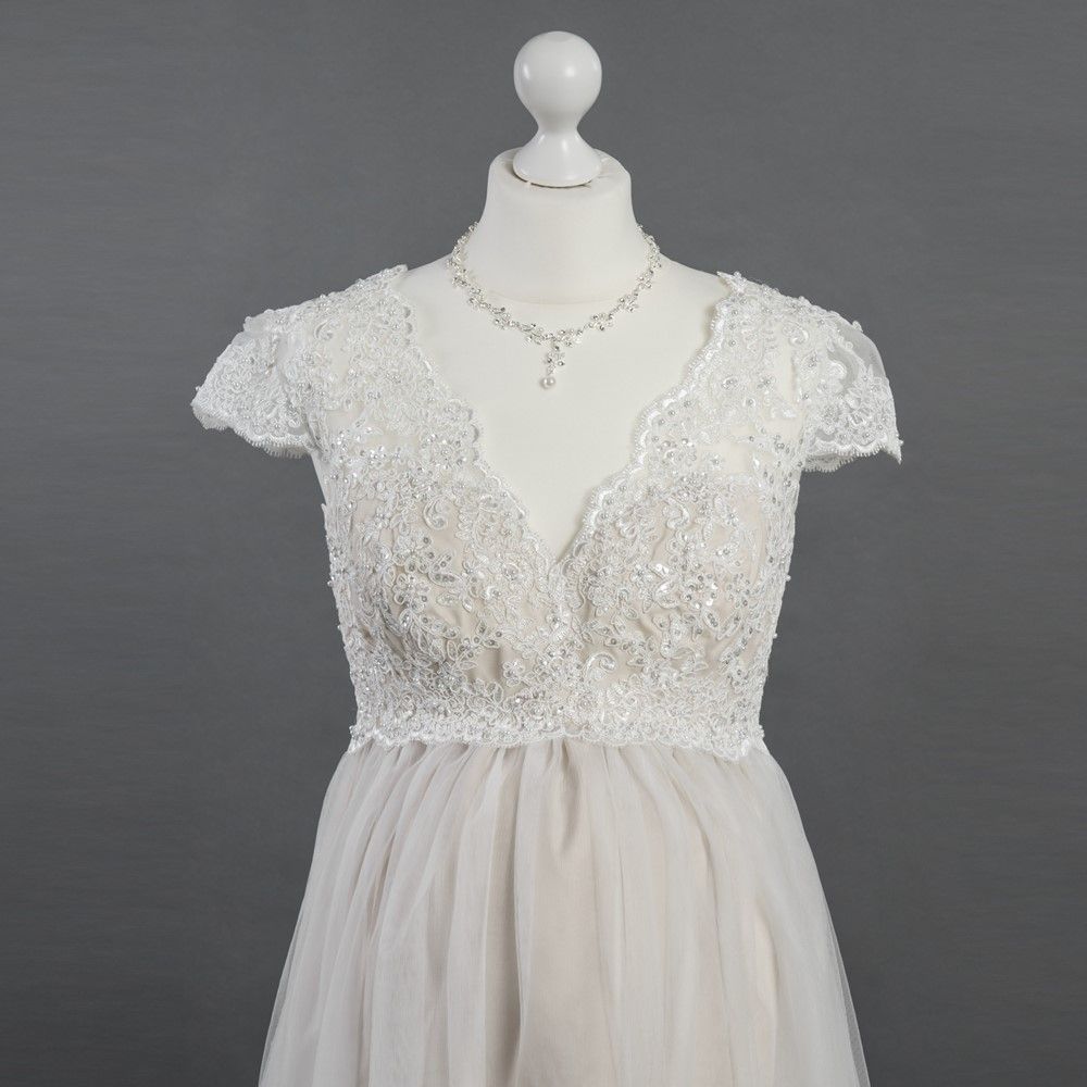 Ein weißes Kleid mit einer Halskette ist auf einer Schaufensterpuppe