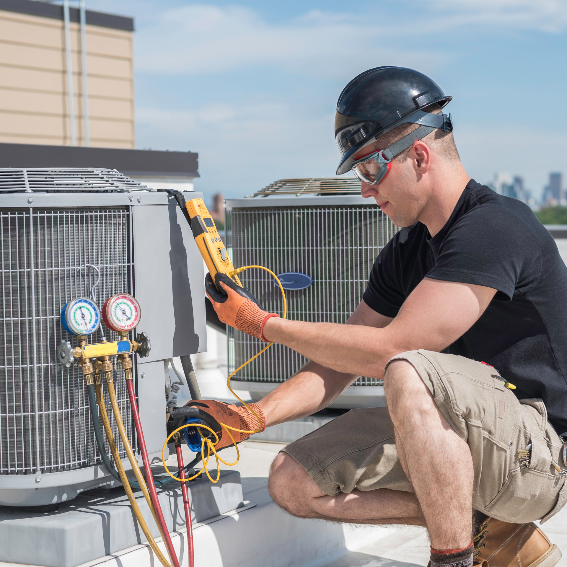 HVAC technician inspecting an air conditioning unit on a rooftop, using gauges and a multimeter.