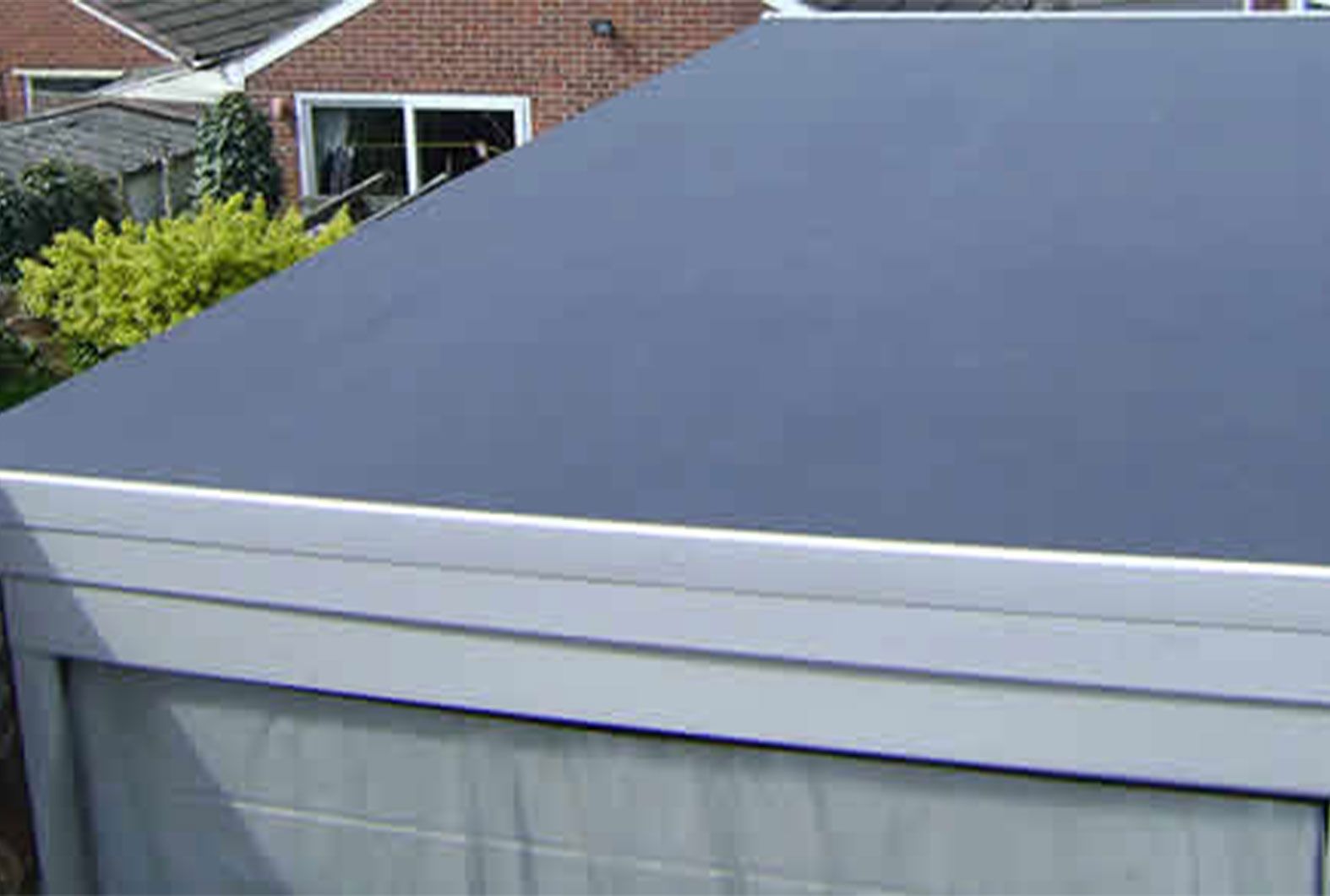A garage with a black roof and a white trim.