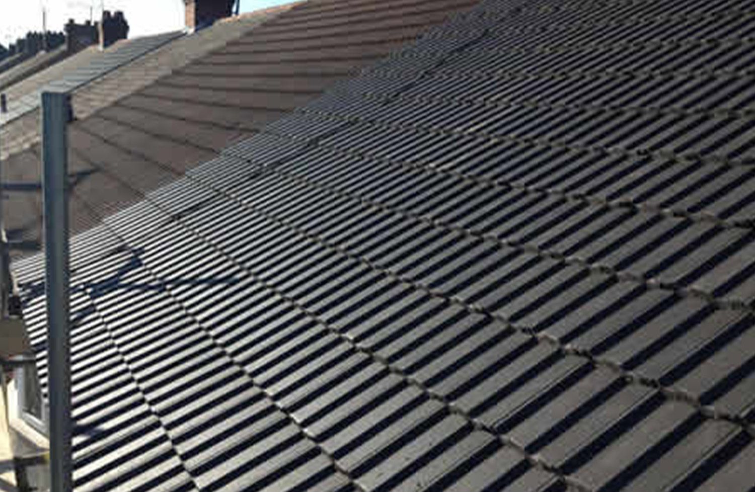A close up of a tiled roof with a chimney on top of it.