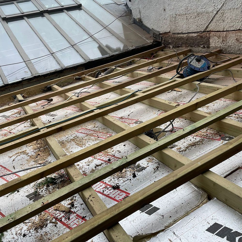 A wooden structure is being built on top of a roof.
