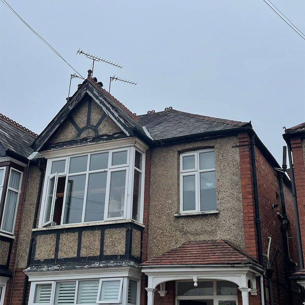 A large brick house with a roof antenna on top of it