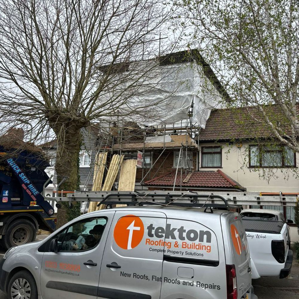A tekton roofing and building van is parked in front of a house.