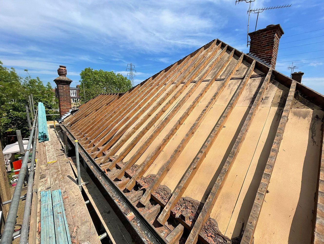 The roof of a building is being remodeled with wooden beams.