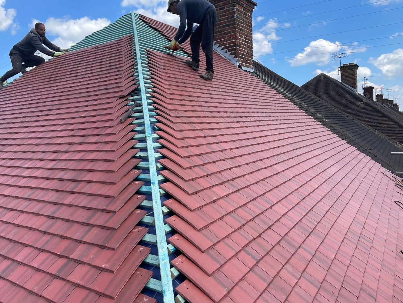 Two men are working on the roof of a building.