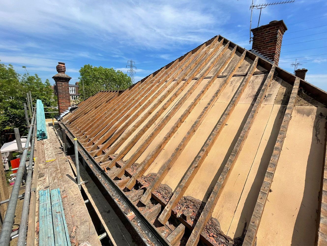 The roof of a house is being remodeled with wooden beams.
