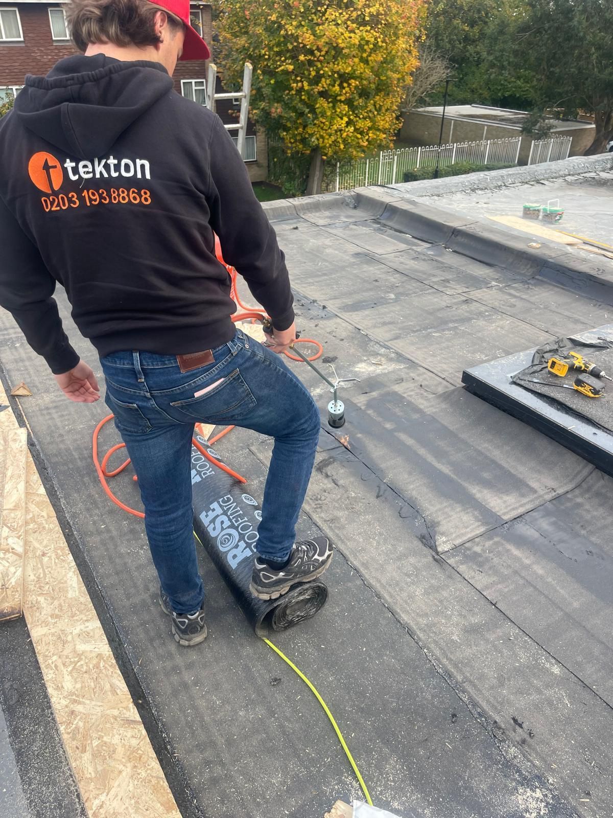 A man is standing on a skateboard on a roof.