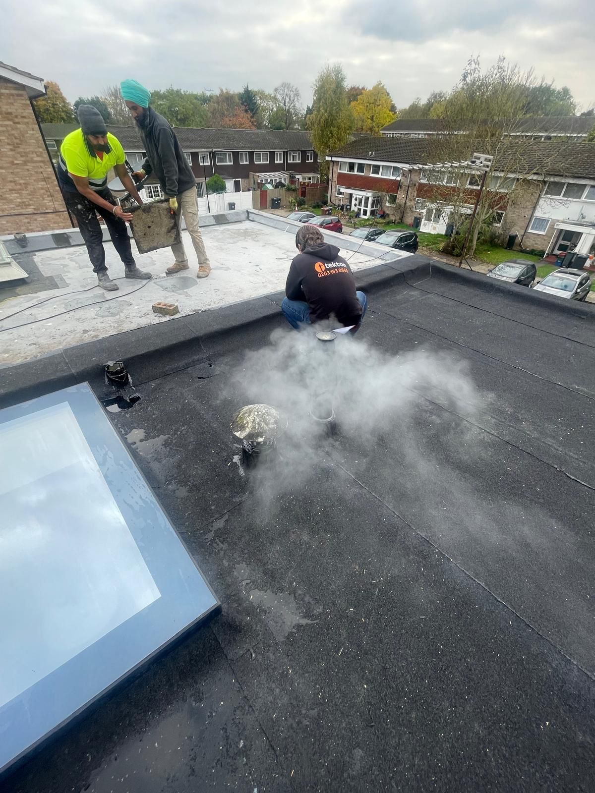 A group of people are working on the roof of a building.