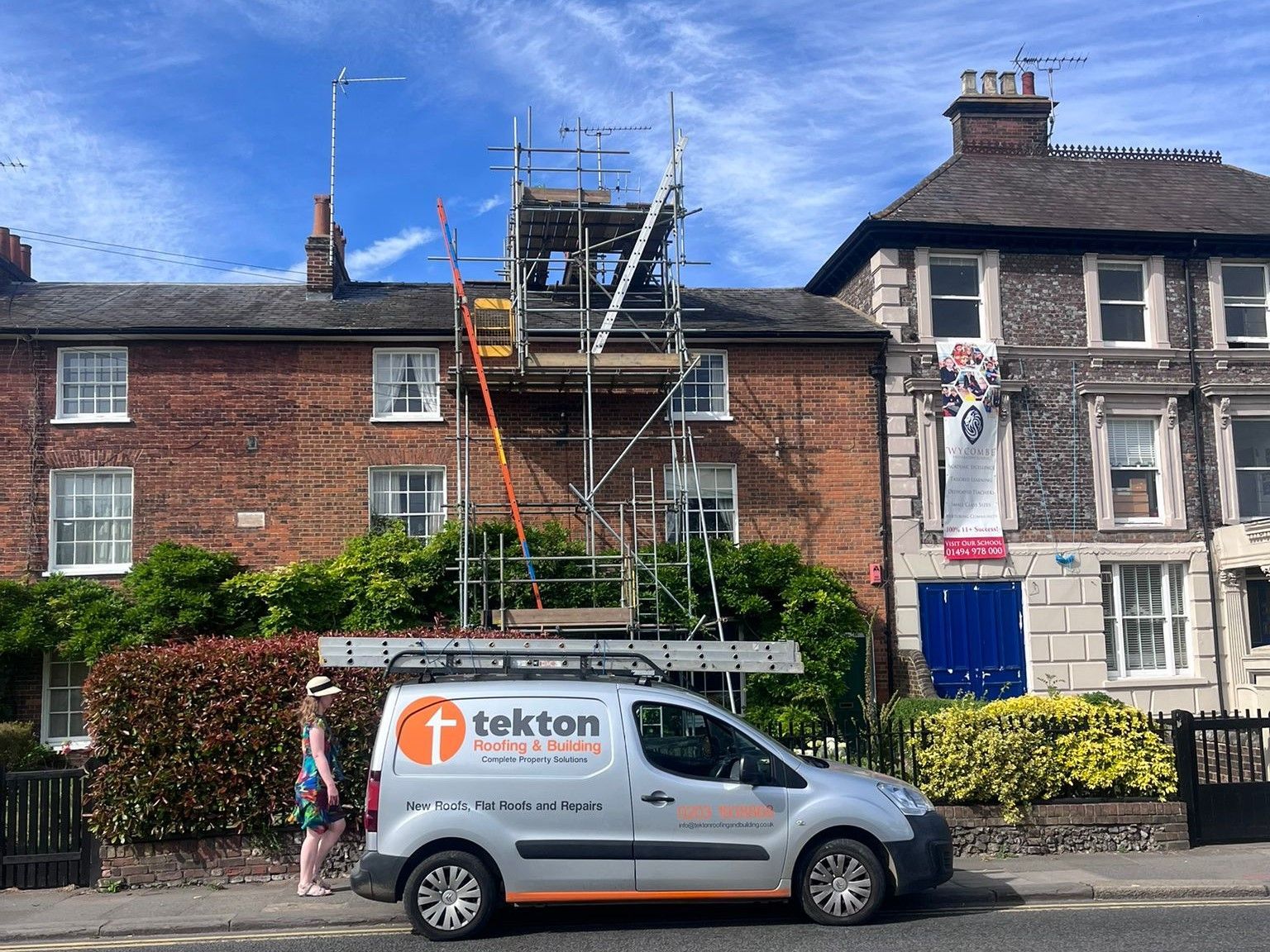 Silver Tekton Roofing & Building van parked in front of a UK brick residential property with scaffolding erected for maintenance