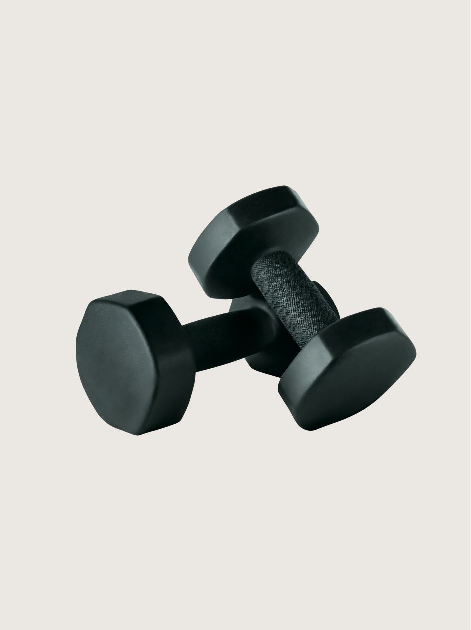 Two black hexagonal dumbbells resting stacked on a plain light background.
