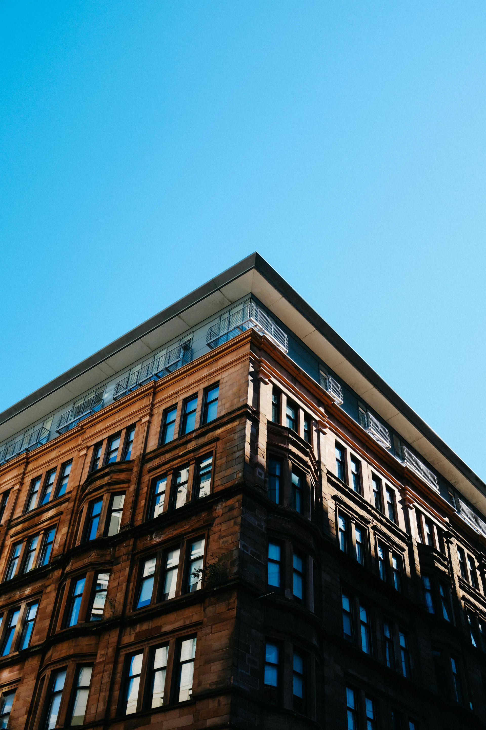 Family, including two children, enters a home through an open doorway, carrying boxes.