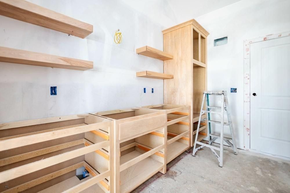A room with wooden shelves and a ladder in it.