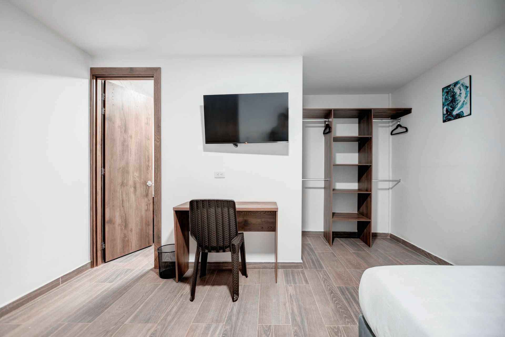 Una habitación de hotel con cama, escritorio, silla y televisión.