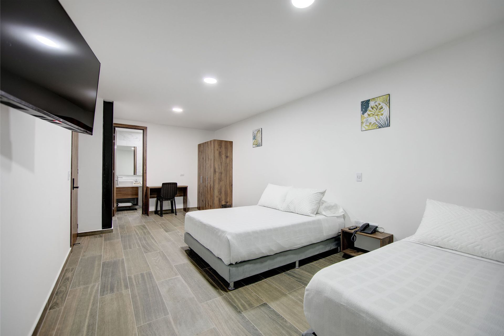 Una habitación de hotel con dos camas y un televisor de pantalla plana