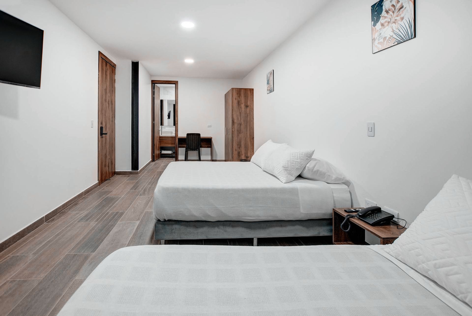 Una habitación de hotel con dos camas y un televisor de pantalla plana