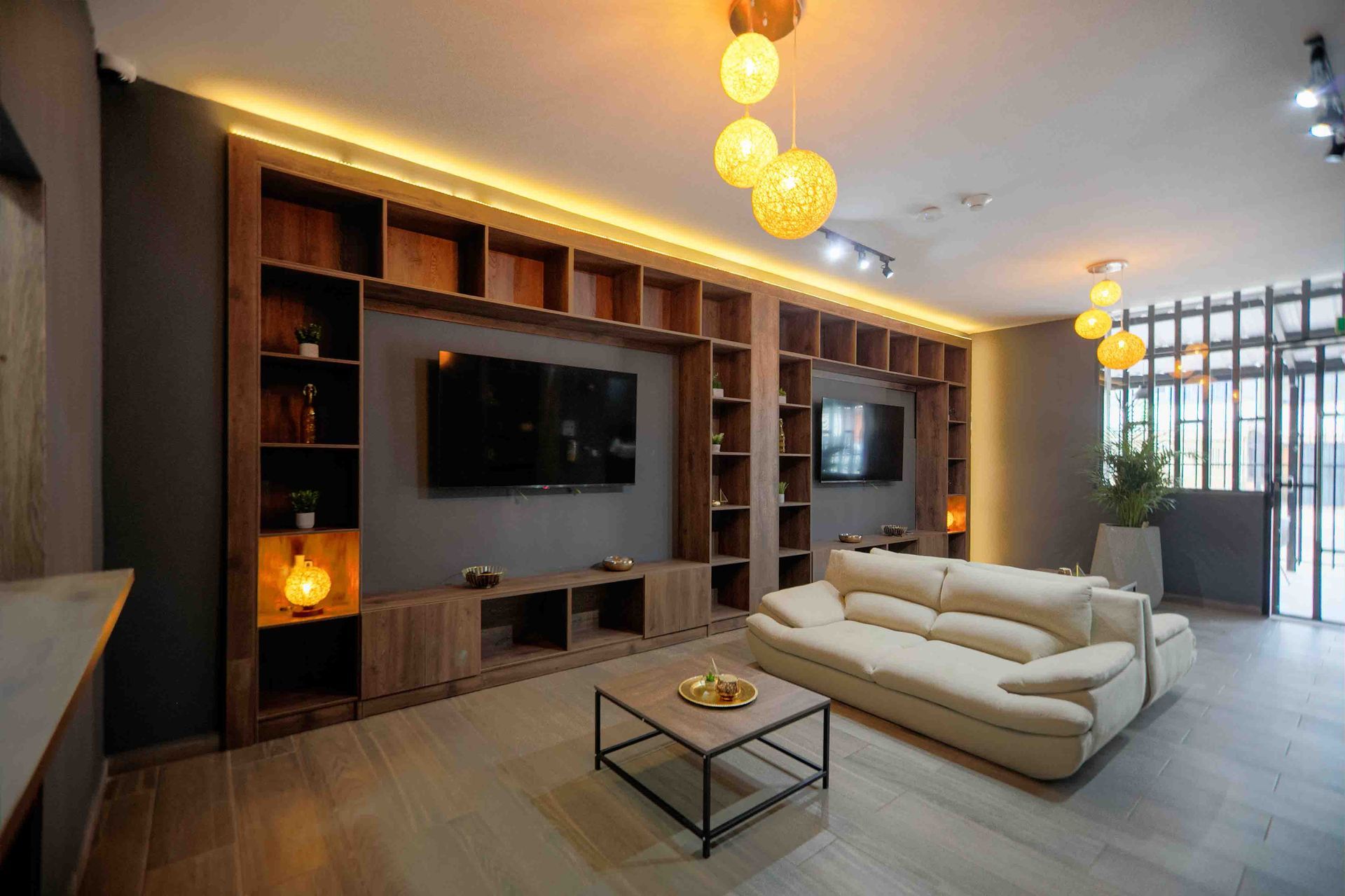 Una sala de estar con sofá , televisión y estanterías.