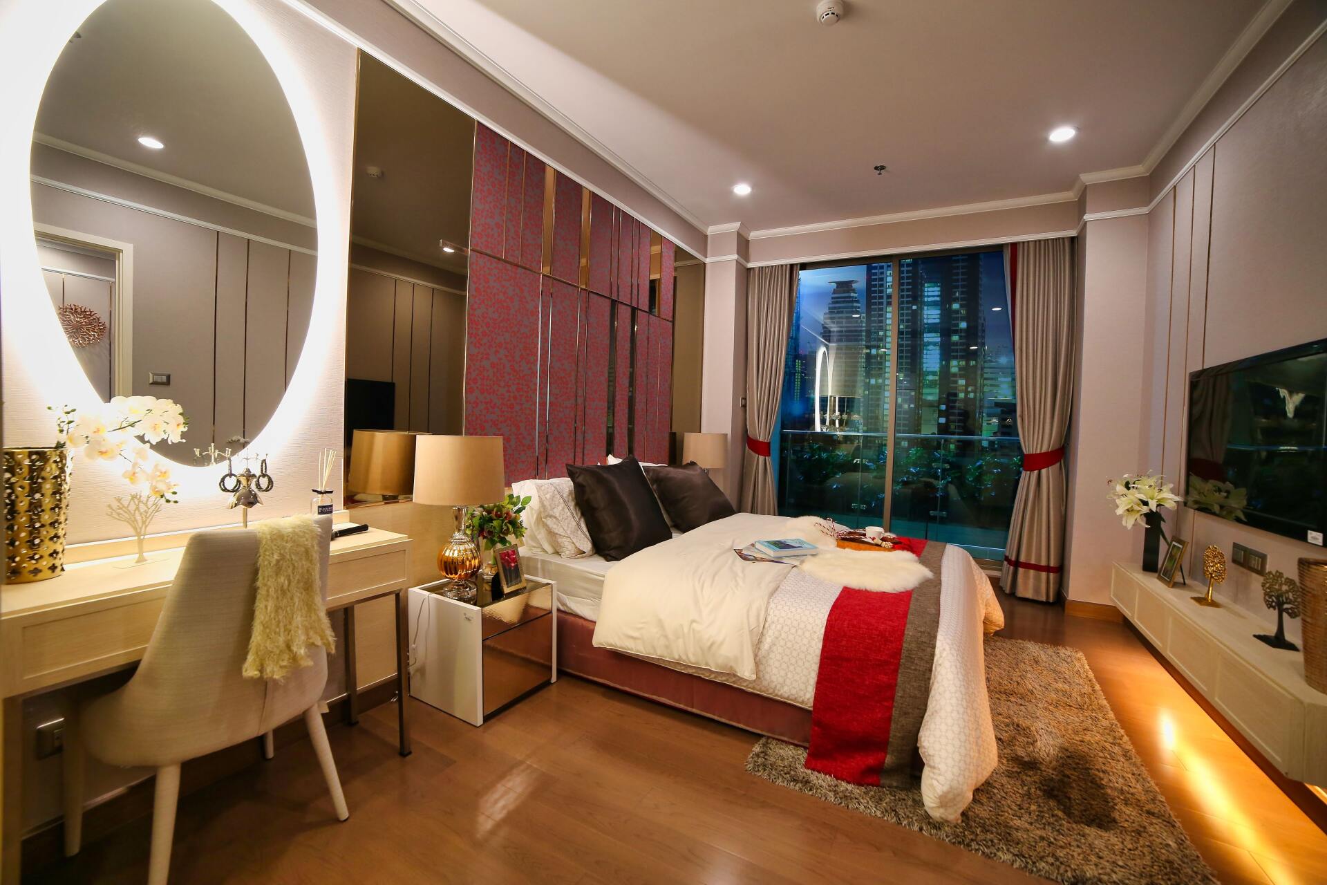 Un dormitorio con una cama grande, cómoda, espejo y televisión.