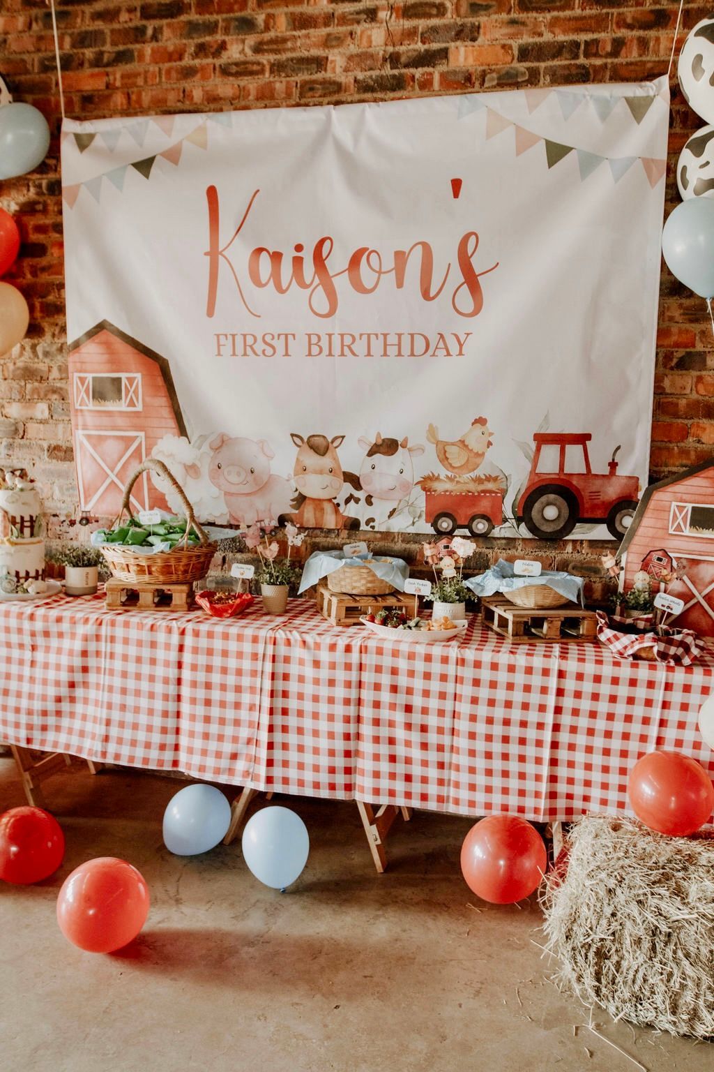 A table with a checkered tablecloth and balloons at a farm themed birthday party.